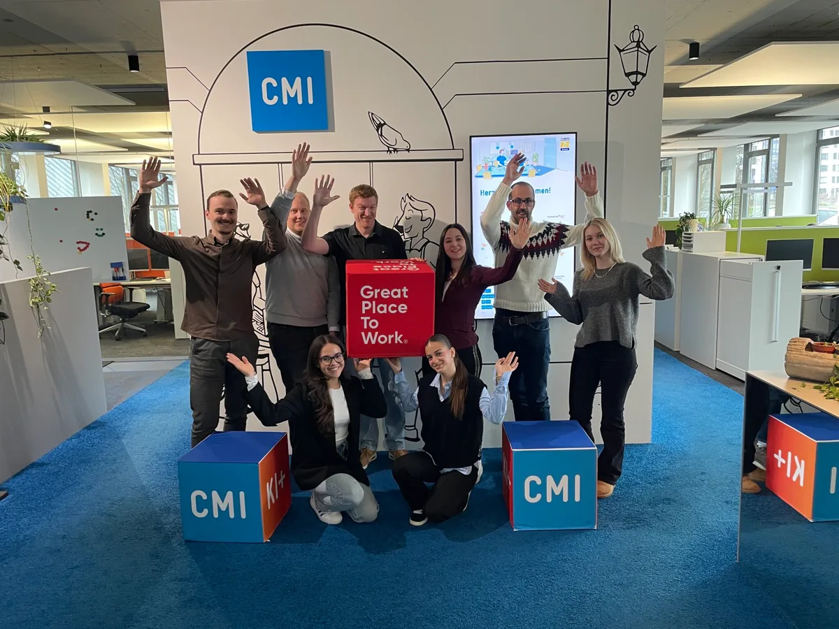 Menschen jubeln vor einem Plakat.